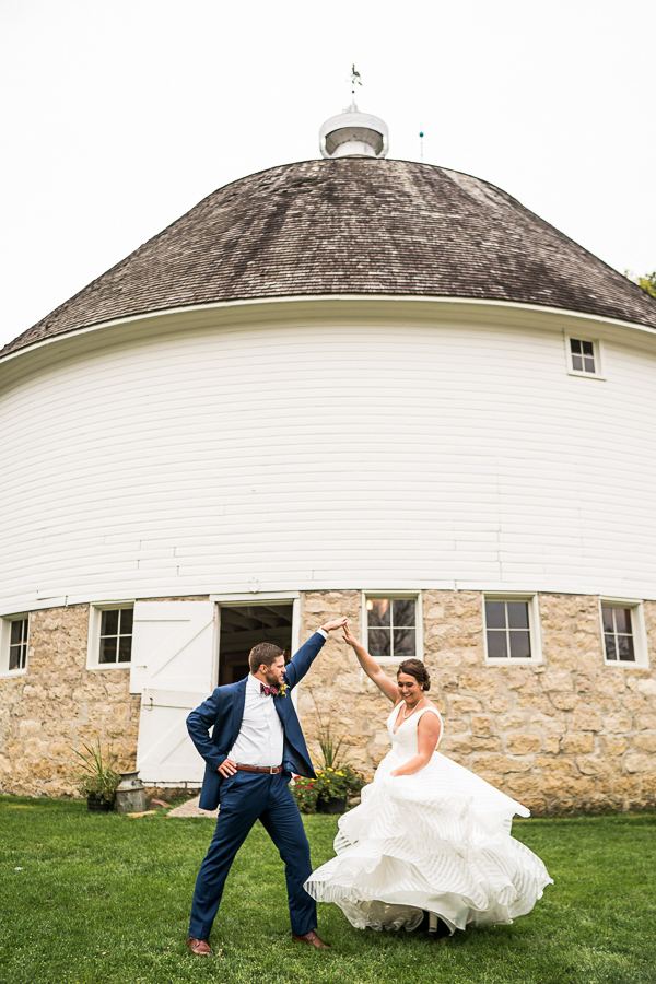 Bride and Groom dancing in front of barn