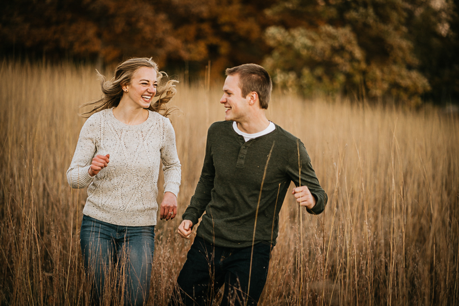 Couple running in tall grasses